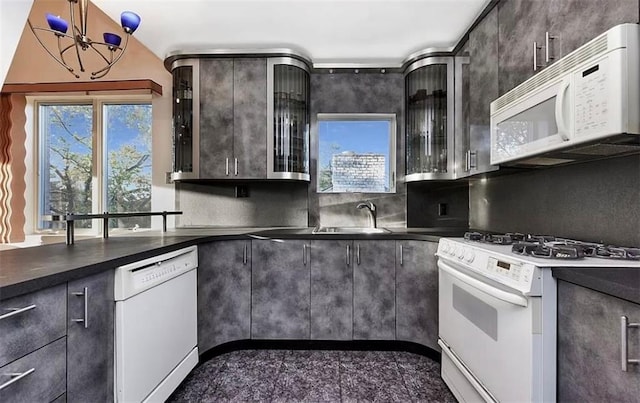 kitchen with white appliances, dark brown cabinetry, sink, and backsplash