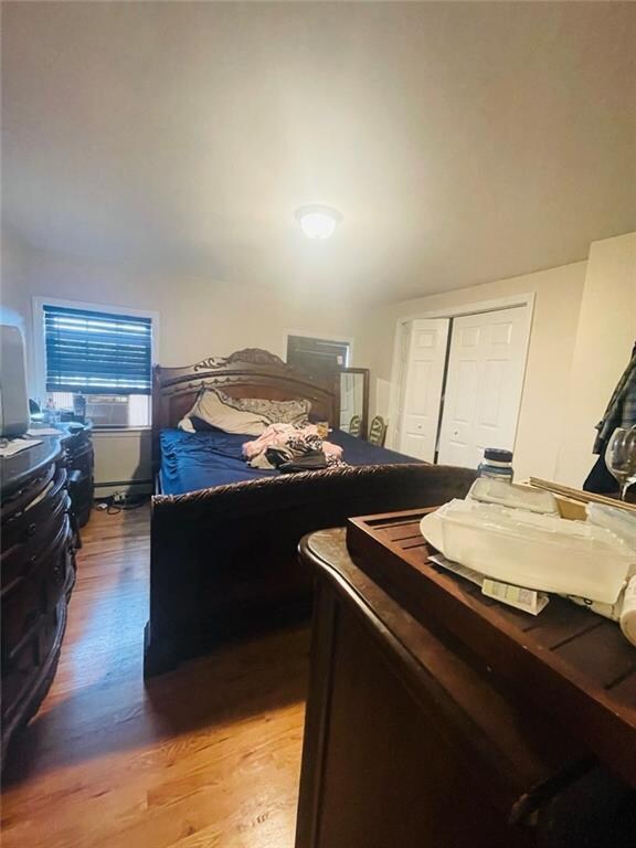 bedroom with wood-type flooring and a closet