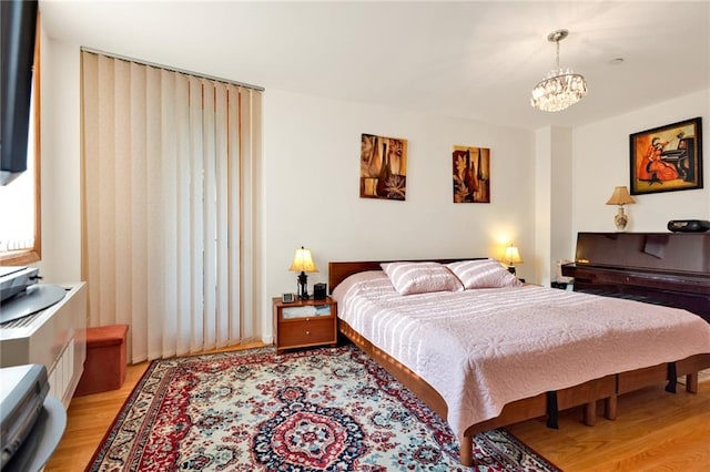 bedroom with light wood finished floors and a notable chandelier