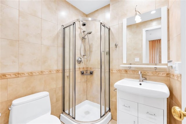 bathroom with toilet, a stall shower, tile walls, and vanity