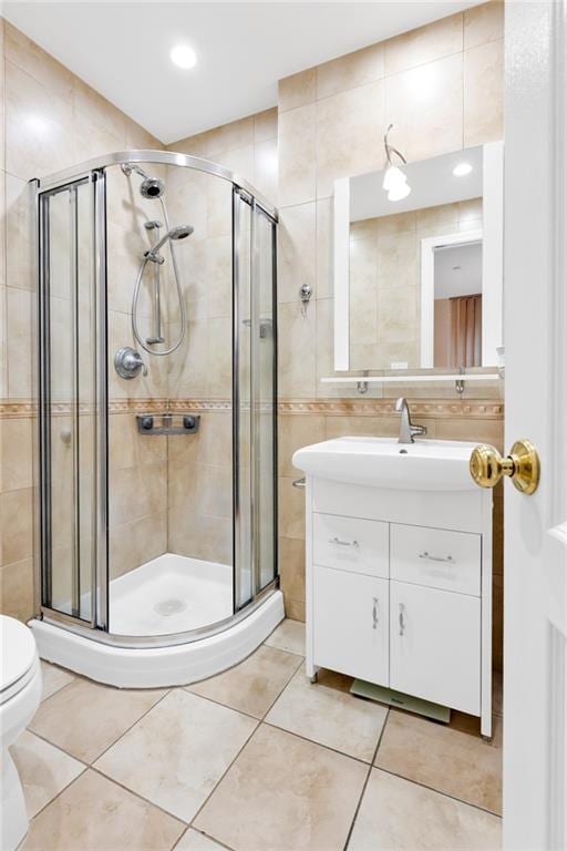 full bath featuring tile walls, tile patterned flooring, and a shower stall