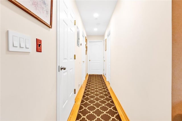 corridor featuring recessed lighting, light wood-type flooring, and baseboards