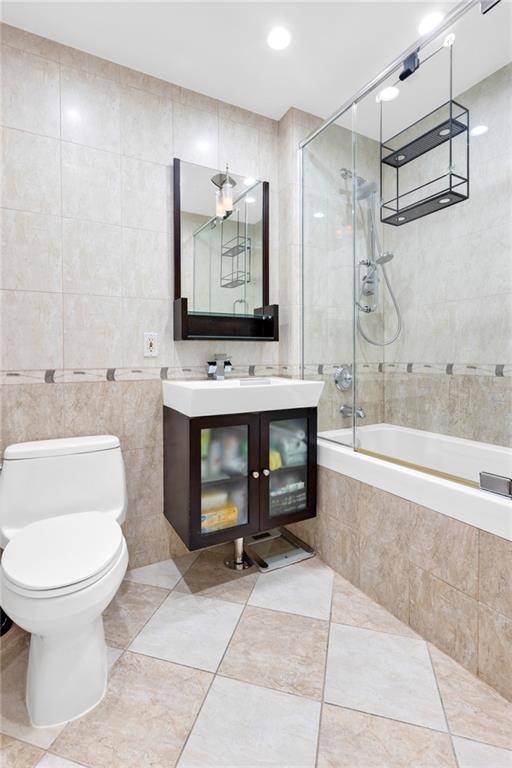 728 Ocean View Ave Unit A2, Brooklyn, NY 11235 - bathroom with tile walls, toilet, vanity, tiled shower / bath combo, and tile patterned flooring