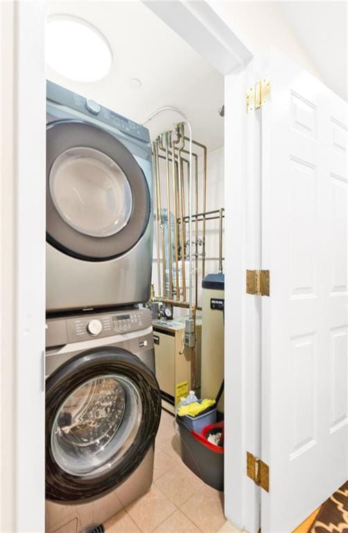 laundry area featuring laundry area, stacked washer / dryer, and tile patterned floors