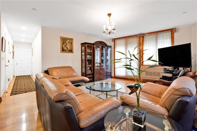 living area with a chandelier, light wood-type flooring, and visible vents