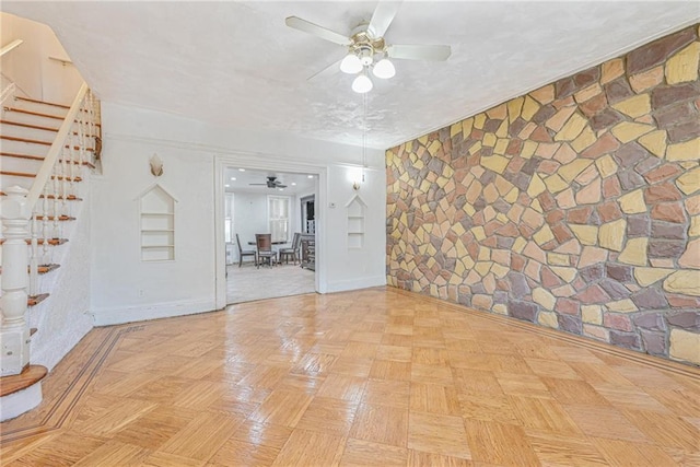 empty room with ceiling fan and light parquet flooring