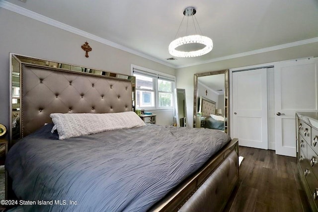 bedroom with visible vents, a chandelier, a closet, dark wood-type flooring, and ornamental molding