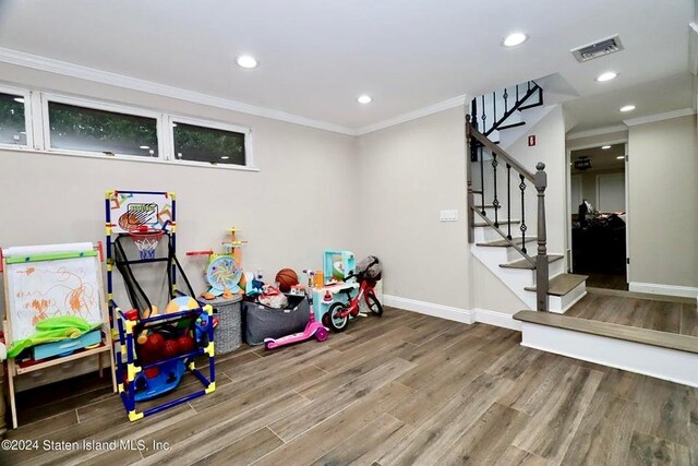 game room featuring wood-type flooring and ornamental molding