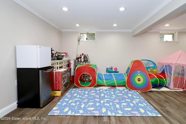 recreation room featuring hardwood / wood-style flooring and crown molding