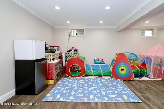 recreation room featuring crown molding, wood finished floors, and recessed lighting