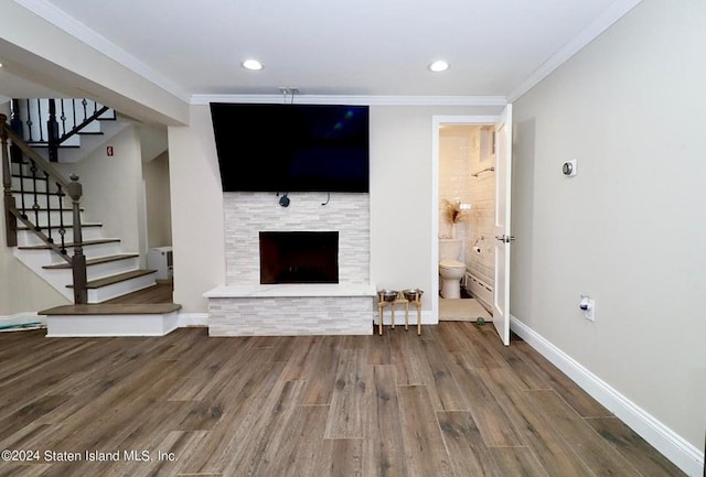 unfurnished living room featuring hardwood / wood-style flooring and crown molding