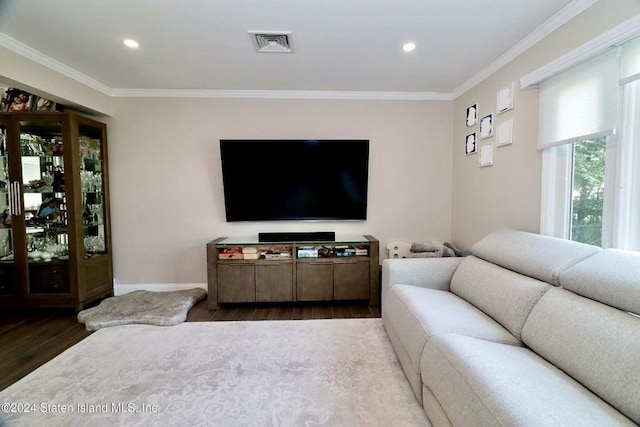living area with baseboards, crown molding, wood finished floors, and visible vents