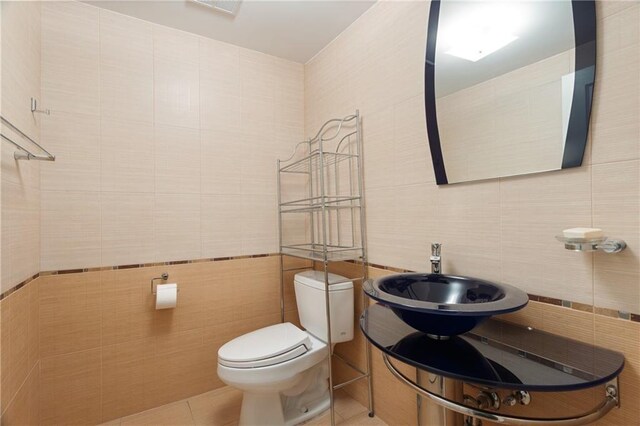 bathroom featuring tile walls, sink, tile patterned flooring, and toilet