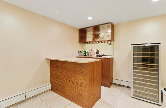 bar with a baseboard heating unit, light tile patterned floors, and beverage cooler