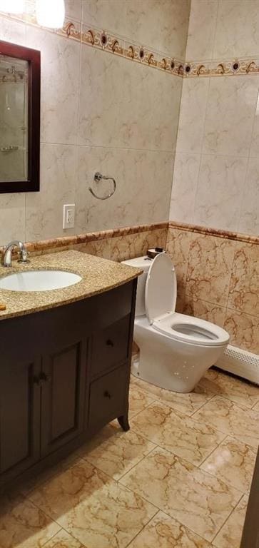 bathroom featuring vanity, toilet, and tile walls