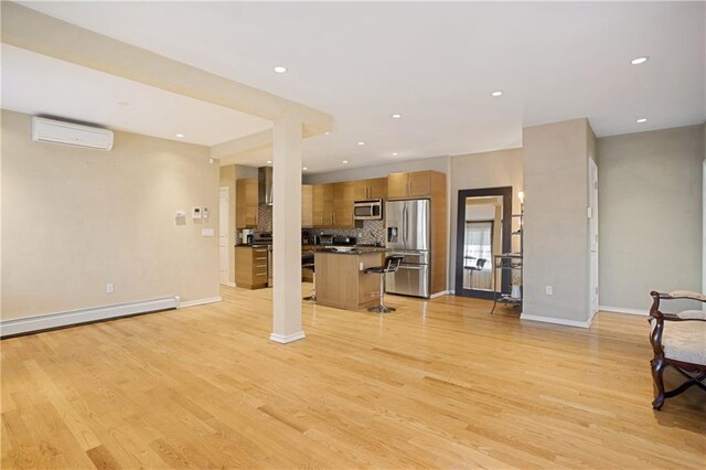 unfurnished living room featuring a baseboard radiator, a wall mounted AC, and light wood-type flooring