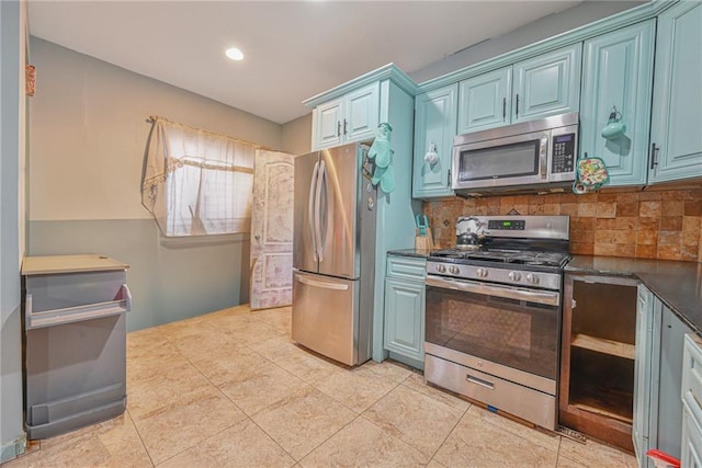 kitchen with backsplash, light tile patterned floors, stainless steel appliances, and blue cabinets