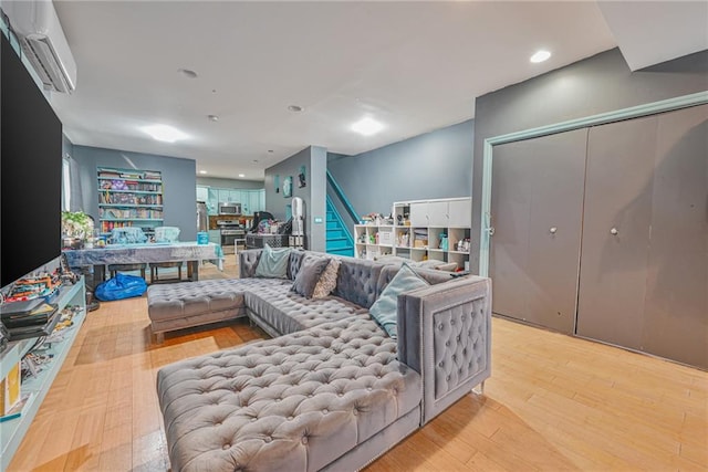 living room with light wood-type flooring and an AC wall unit