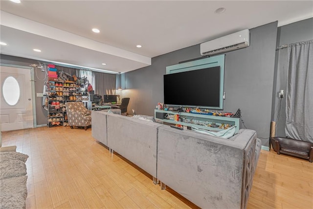 living room with a wall mounted AC and light hardwood / wood-style floors