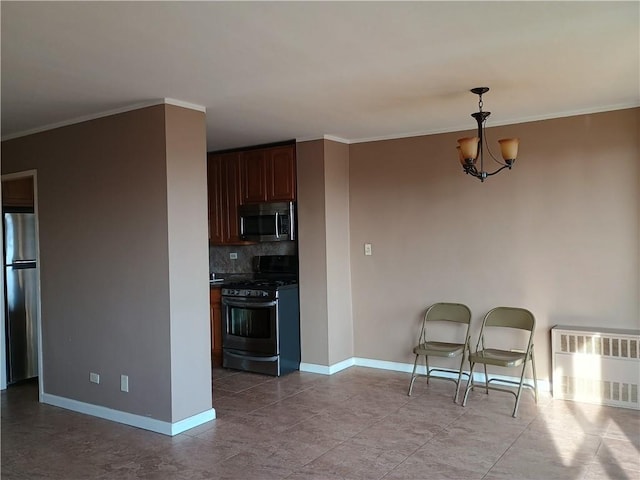 kitchen featuring appliances with stainless steel finishes, radiator heating unit, decorative backsplash, ornamental molding, and an inviting chandelier