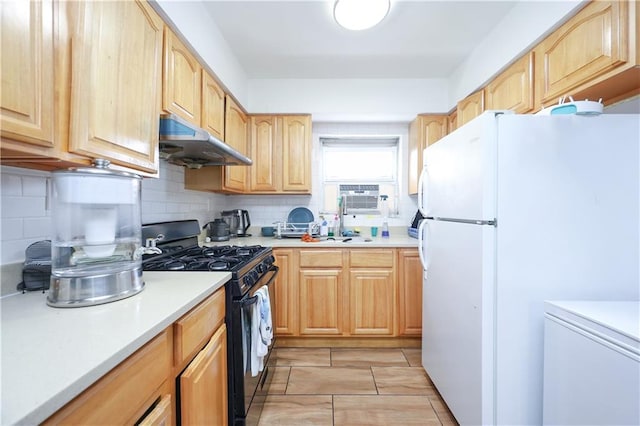 kitchen featuring black gas range oven, white fridge, backsplash, light tile patterned floors, and light brown cabinets