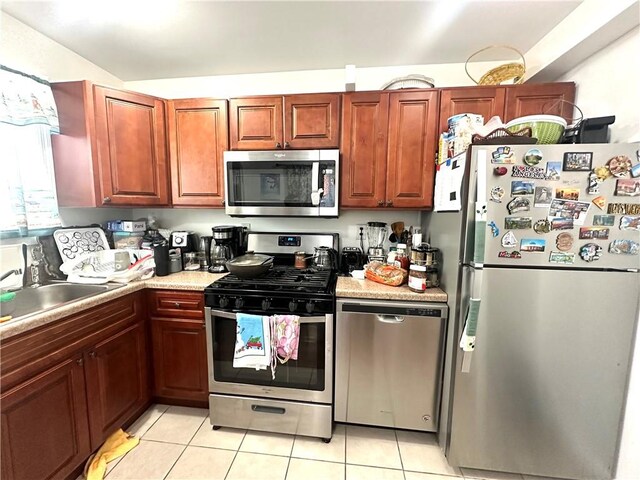 kitchen featuring stainless steel appliances, sink, and light tile patterned floors