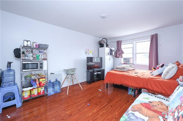 bedroom with cooling unit and wood-type flooring