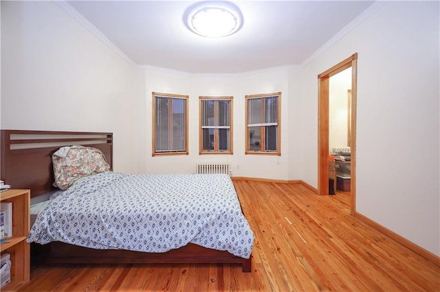 bedroom featuring radiator, wood-type flooring, and ornamental molding