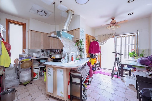 kitchen featuring kitchen peninsula, light brown cabinetry, a kitchen breakfast bar, ceiling fan, and pendant lighting