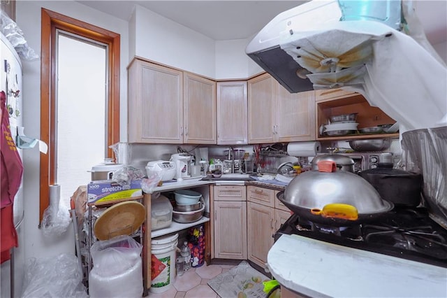 kitchen featuring light brown cabinets, light tile patterned floors, and exhaust hood