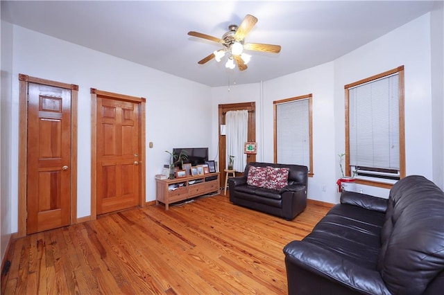 living room with ceiling fan and light hardwood / wood-style flooring