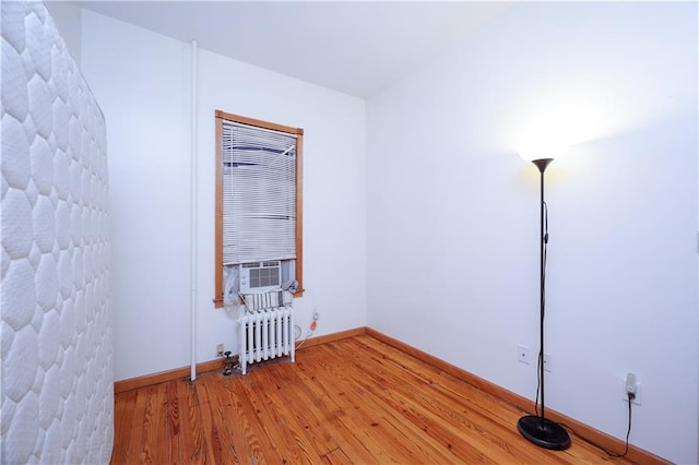 unfurnished room featuring hardwood / wood-style floors and radiator