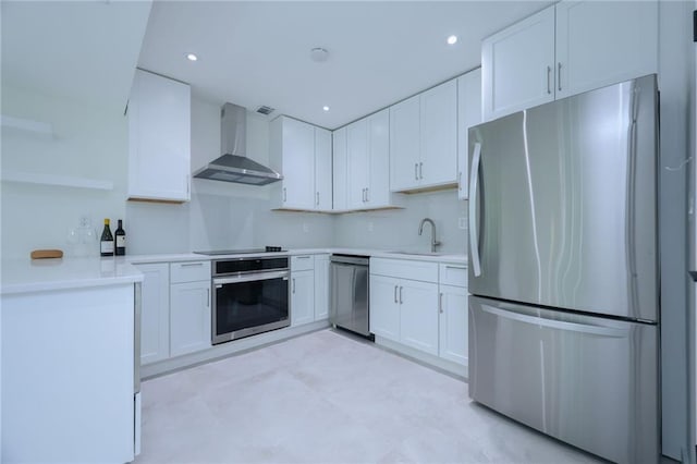 kitchen with sink, white cabinets, wall chimney range hood, and stainless steel appliances