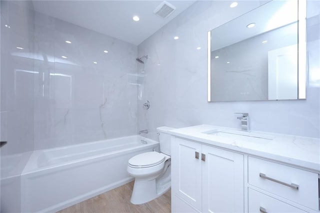 full bathroom with vanity, toilet, tiled shower / bath combo, and hardwood / wood-style floors