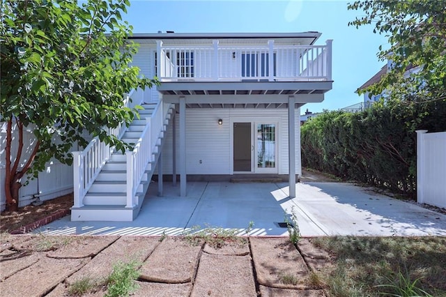 rear view of property featuring a balcony and a patio