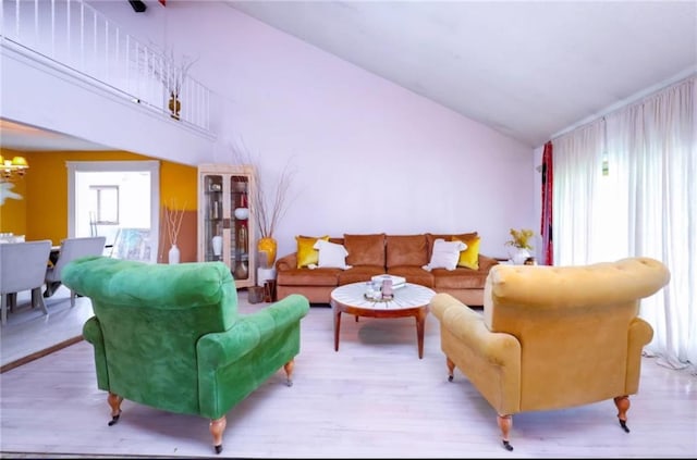 living area with a healthy amount of sunlight, a notable chandelier, and wood finished floors