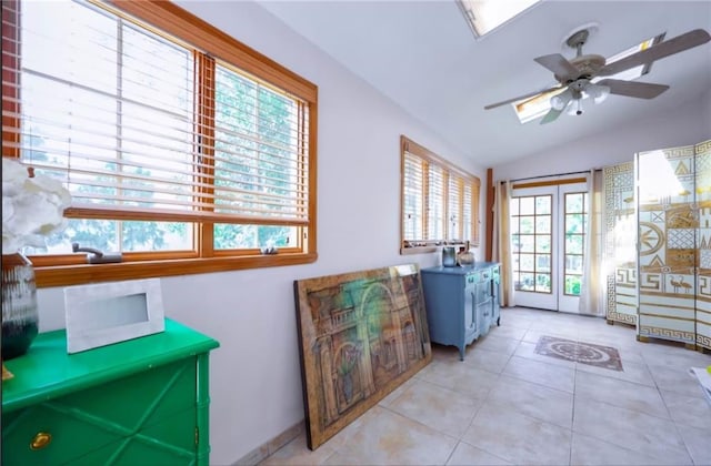 interior space featuring lofted ceiling, ceiling fan, and light tile patterned floors