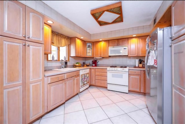 kitchen featuring light tile patterned flooring, white appliances, a sink, light countertops, and backsplash