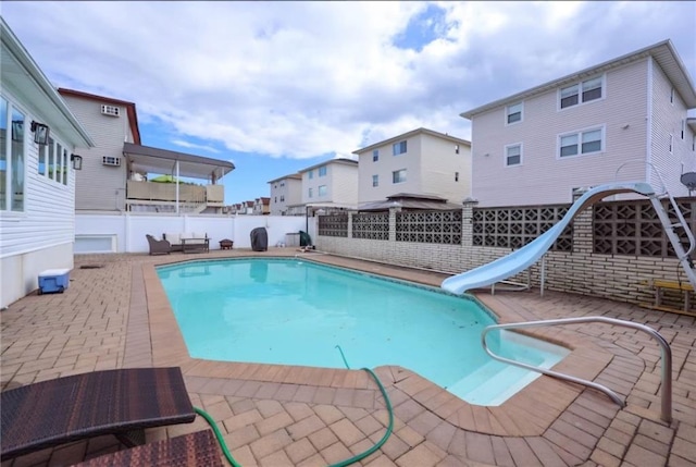 view of swimming pool with a patio and a water slide