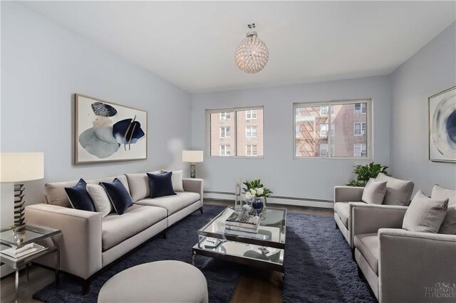 living room with a baseboard heating unit and dark hardwood / wood-style floors