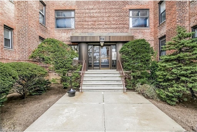 doorway to property featuring french doors and brick siding