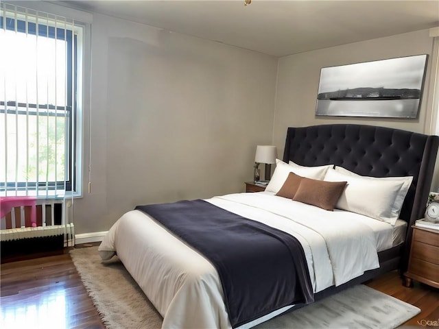 bedroom with baseboards and wood finished floors