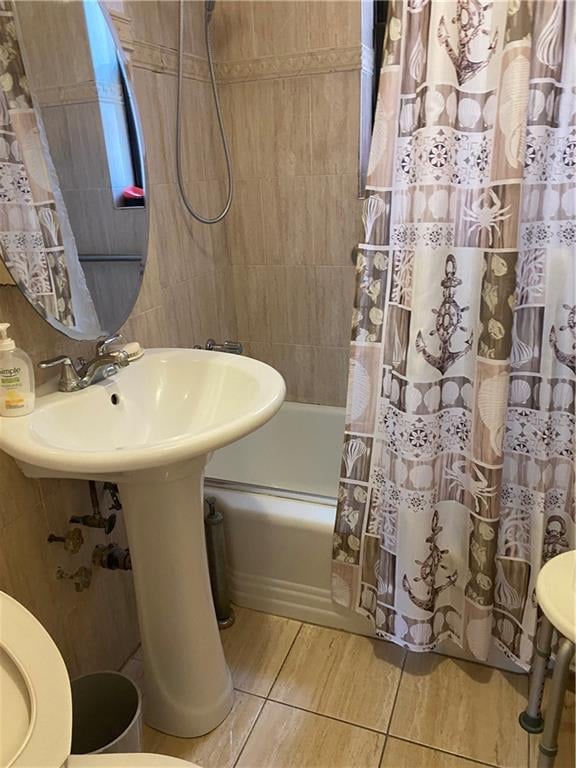 bathroom with shower / bath combination with curtain and toilet