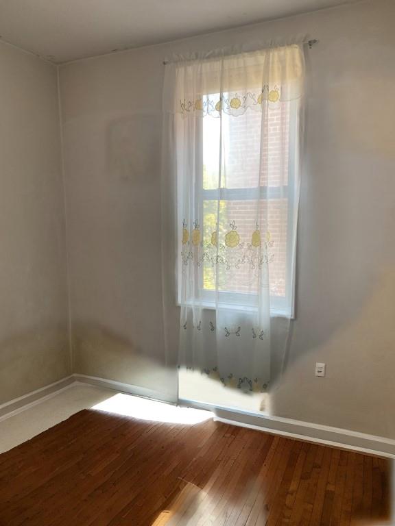 unfurnished room featuring plenty of natural light and hardwood / wood-style floors