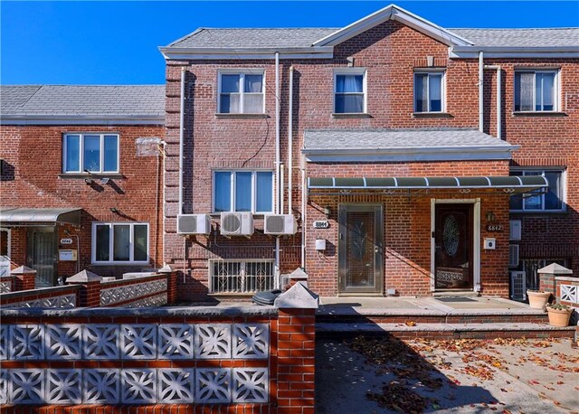 townhome / multi-family property featuring a wall unit AC