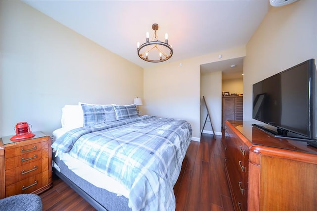 bedroom featuring dark wood-type flooring, a notable chandelier, and baseboards