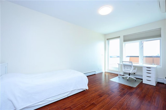 bedroom featuring dark hardwood / wood-style floors and a baseboard heating unit