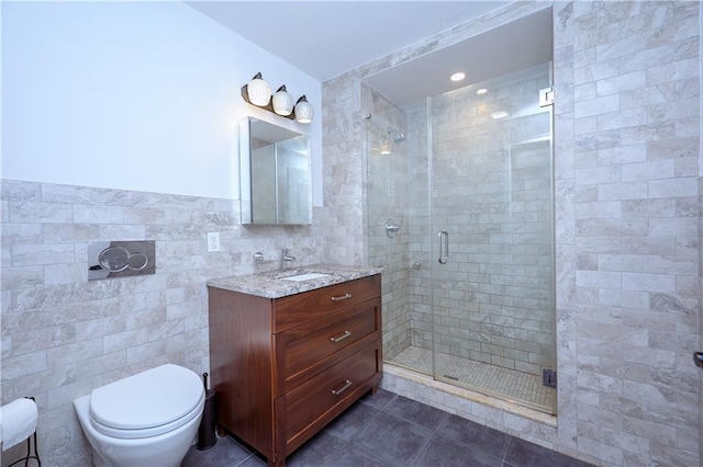 bathroom with vanity, tile walls, tile patterned flooring, toilet, and a shower with shower door