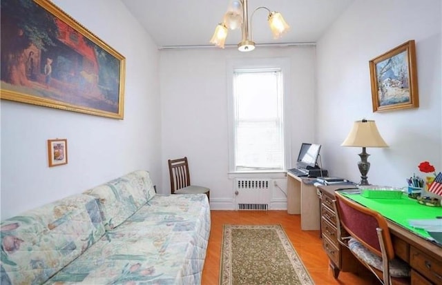 office with radiator, a notable chandelier, and wood finished floors