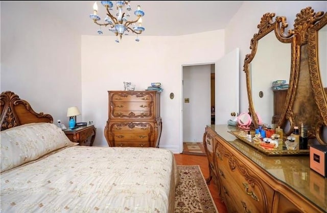 bedroom with wood-type flooring and a notable chandelier